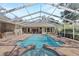A beautiful enclosed swimming pool is surrounded by brick patio and glass doors to the home at 6007 Hammock Hill Ave, Lithia, FL 33547