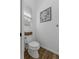 Small toilet room with art, white toilet and a basket for storage at 6007 Hammock Hill Ave, Lithia, FL 33547