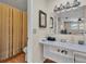 Standard bathroom with a white sink, wood-look vinyl flooring and shower with yellow curtain at 114 Windy Pl, Brandon, FL 33511