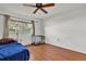 Bright bedroom featuring wood floors, a ceiling fan, and natural light from the window at 114 Windy Pl, Brandon, FL 33511
