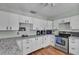 Bright kitchen with white cabinets, stainless steel appliances, and granite countertops, offering ample space at 114 Windy Pl, Brandon, FL 33511
