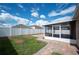 Spacious backyard featuring green grass, a brick patio, white fencing, and a screened-in patio at 3425 San Moise Pl, Plant City, FL 33567