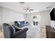 A bright living room with tile floors, two blue sofas, a fan, and a TV at 3425 San Moise Pl, Plant City, FL 33567