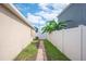Side yard of home has white fencing, lush plantings, and a brick path at 3425 San Moise Pl, Plant City, FL 33567