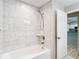 A bright bathroom with a new tub/shower combination with bright white tile at 12043 Centralia Rd, Weeki Wachee, FL 34614