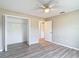 A neutral bedroom features wood-look floors, a ceiling fan, and an open closet for storage at 12043 Centralia Rd, Weeki Wachee, FL 34614