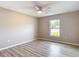 Bright bedroom featuring wood-look floors, a ceiling fan, and a window with a view of the outdoors at 12043 Centralia Rd, Weeki Wachee, FL 34614