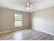 Bright bedroom featuring wood-look floors, a ceiling fan, and a window with a view of the outdoors at 12043 Centralia Rd, Weeki Wachee, FL 34614