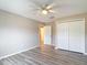 Neutral bedroom with wood floors, a ceiling fan, and a closet with bi-fold doors at 12043 Centralia Rd, Weeki Wachee, FL 34614