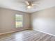 Bright bedroom featuring wood-look floors, a ceiling fan, and a window with a view of the outdoors at 12043 Centralia Rd, Weeki Wachee, FL 34614