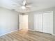 Bedroom with wood-look floors, ceiling fan, closet and white trim at 12043 Centralia Rd, Weeki Wachee, FL 34614