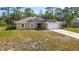 Charming single-story home featuring a spacious front yard, attached two-car garage, and neutral color palette at 12043 Centralia Rd, Weeki Wachee, FL 34614