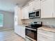 Modern kitchen features white cabinetry, stainless steel appliances, and granite countertops at 12043 Centralia Rd, Weeki Wachee, FL 34614