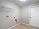 Bright laundry room with wood-look floors, utility connections and wire shelving for easy storage at 12043 Centralia Rd, Weeki Wachee, FL 34614