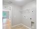Bright laundry room with utility connections, wire shelving and access to other rooms at 12043 Centralia Rd, Weeki Wachee, FL 34614