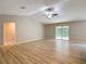 Spacious living room featuring wood flooring, high ceilings, and sliding doors to the backyard at 12043 Centralia Rd, Weeki Wachee, FL 34614