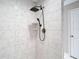 Modern shower with marble-look tile and black fixtures at 12043 Centralia Rd, Weeki Wachee, FL 34614