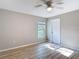 Bedroom with wood-look floors, ceiling fan, and a window plus a white door at 12053 Centralia Rd, Weeki Wachee, FL 34614
