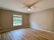 Comfortable bedroom showcasing wood floors, neutral walls, a ceiling fan, and natural light at 12053 Centralia Rd, Weeki Wachee, FL 34614