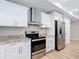 Kitchen featuring white cabinets, stainless steel appliances, granite countertops, and wood-look flooring at 12053 Centralia Rd, Weeki Wachee, FL 34614