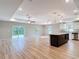 Open-concept living room and kitchen with hardwood floors, a ceiling fan, and sliding glass doors at 12053 Centralia Rd, Weeki Wachee, FL 34614