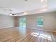 Spacious living room with wood-look floors, tray ceilings, fan, and sliding glass doors to backyard at 12053 Centralia Rd, Weeki Wachee, FL 34614