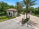 Gated community entrance featuring a charming guard house, palm trees, and lush landscaping at 20159 Umbria Hill Dr, Tampa, FL 33647