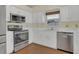 Bright kitchen with stainless steel appliances, white cabinets, and hardwood floors at 625 Chilt Dr, Brandon, FL 33510