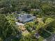 Expansive aerial view of estate home with a screened pool, mature landscaping, and an expansive lot with defined property lines at 7313 Crape Myrtle Way, Sarasota, FL 34241