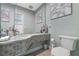 The guest bath features a granite countertop with mosaic tile, a single sink and a toilet at 7313 Crape Myrtle Way, Sarasota, FL 34241