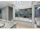 Bathroom with a large soaking tub surrounded by mirrors with great views of the backyard at 7313 Crape Myrtle Way, Sarasota, FL 34241