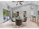 This dining room has a glass table with four chairs, a ceiling fan, and sliding glass doors that open to the pool at 7313 Crape Myrtle Way, Sarasota, FL 34241