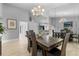 Open-concept dining room with hardwood floors, modern chandelier, and views of the living spaces at 7313 Crape Myrtle Way, Sarasota, FL 34241