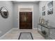 Elegant foyer with wood-look tile floors, modern decor, and a double-door entry at 7313 Crape Myrtle Way, Sarasota, FL 34241