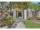 Charming home entrance with decorative pillars, a stone pathway, and verdant landscaping at 7313 Crape Myrtle Way, Sarasota, FL 34241