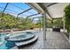 Relaxing hot tub inside screened enclosure next to pool and outdoor kitchen at 7313 Crape Myrtle Way, Sarasota, FL 34241
