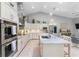 This open kitchen offers white cabinets, stainless steel appliances, pendant lighting and a center island with bar seating at 7313 Crape Myrtle Way, Sarasota, FL 34241