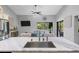 Kitchen island featuring marble countertop, stainless steel sink and view into breakfast nook overlooking the pool at 7313 Crape Myrtle Way, Sarasota, FL 34241