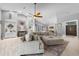 This bright living room features high ceilings, a ceiling fan, and a large sectional sofa with an ottoman and fireplace at 7313 Crape Myrtle Way, Sarasota, FL 34241