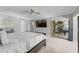 Bright main bedroom with ceiling fan, TV, large sliding glass doors accessing patio, and neutral décor at 7313 Crape Myrtle Way, Sarasota, FL 34241