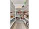 A walk-in pantry offers organized storage with white shelving and recessed lighting at 7313 Crape Myrtle Way, Sarasota, FL 34241