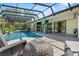 Inviting screened-in pool area with lounge seating and lush green landscaping for relaxing at 7313 Crape Myrtle Way, Sarasota, FL 34241