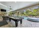 Spacious pool area with pool table, jacuzzi, screened-in enclosure and lush landscaping at 7313 Crape Myrtle Way, Sarasota, FL 34241