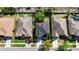 Aerial view of a well-maintained home with a dark roof, lush greenery, and a driveway with a parked red truck at 1401 Parker Den Dr, Ruskin, FL 33570
