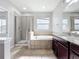 This bathroom has a walk-in shower and a tub at 1401 Parker Den Dr, Ruskin, FL 33570