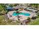 Aerial view showcasing community pool with lounge chairs, palm tree and nearby covered picnic area at 1401 Parker Den Dr, Ruskin, FL 33570