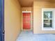 Inviting front entrance features a striking red door, window, and neutral exterior at 1401 Parker Den Dr, Ruskin, FL 33570