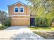 Charming two-story home with a well-manicured lawn, two-car garage, and inviting front entrance at 1401 Parker Den Dr, Ruskin, FL 33570