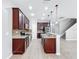 Stylish kitchen showcases dark wood cabinets, granite countertops, stainless appliances, and a functional center island with sink at 1401 Parker Den Dr, Ruskin, FL 33570