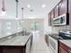 Contemporary kitchen featuring stainless steel appliances, granite countertops, and a convenient island overlooking the backyard at 1401 Parker Den Dr, Ruskin, FL 33570